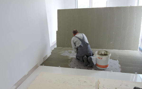 Per ottenere una posa possibilmente senza vuoti delle lastre in grès porcellanato di grande formato i piastrellisti hanno applicato l'adesivo PCI Flexmörtel S1 Flott sul sottofondo preparato e sul retro delle piastrelle.