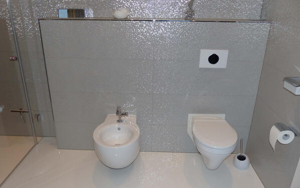 Sulle pareti del bagno sono state posati circa 40 m² di piastrelle di grande formato 33 x 100 cm.